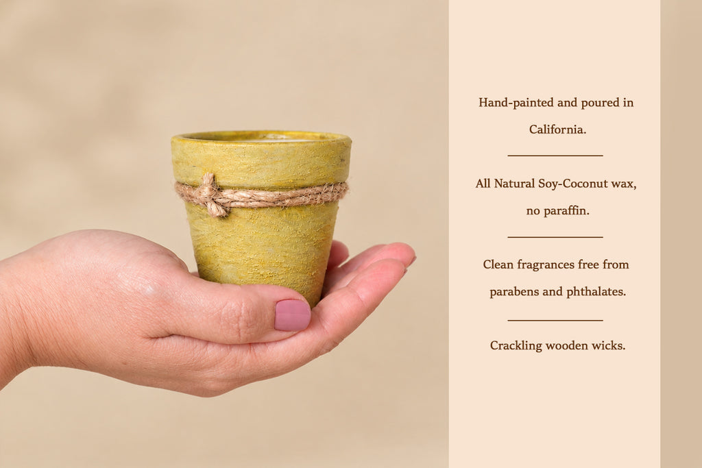 A hand holds a small yellow-green ceramic candle holder wrapped with natural jute twine, next to a beige text panel describing the candle's hand-painted finish, soy-coconut wax, and natural fragrance.