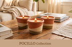 Three lit ceramic candles in terracotta, cream, and olive-green striped tumblers on a rustic wooden table in a cozy living room setting, with a sofa and books in the background. Text overlay at the bottom reads 'POCILLO Collection'.